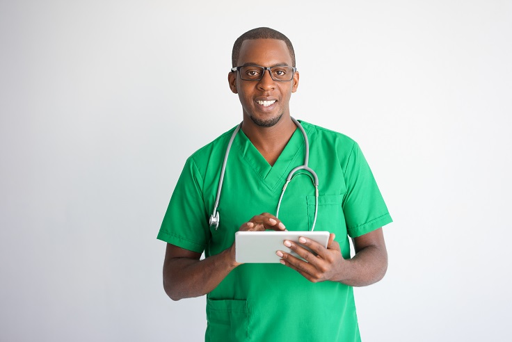 Happy black male doctor using tablet computer. Technology in medicine concept. Isolated front view on white background.